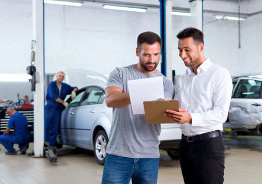 Cliente declarando siniestro con seguro en Multicar Audaz junto a asesor de seguros, taller automotriz en Ate y Comas
