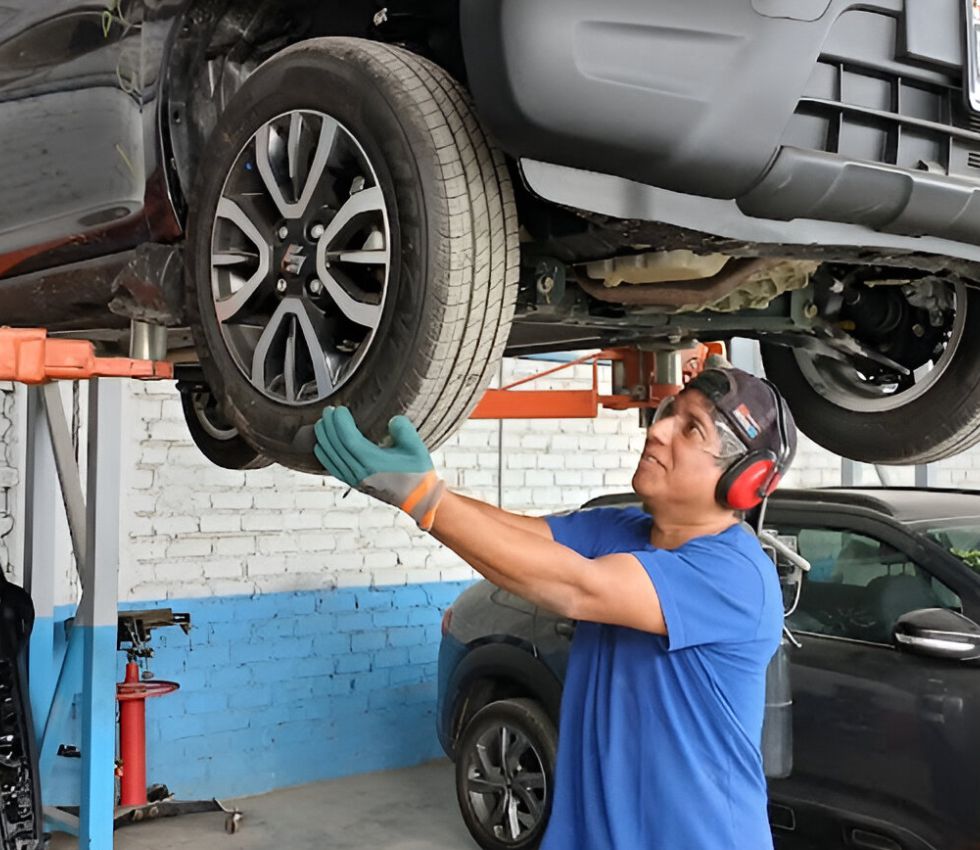 Mecánico especializado revisando el motor de un auto durante una reparación correctiva en Multicar Audaz